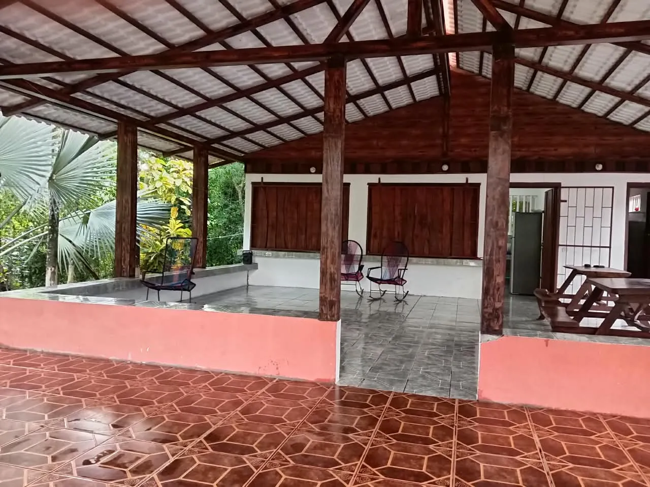 Roofed terrace with tiled floor and picnic tables